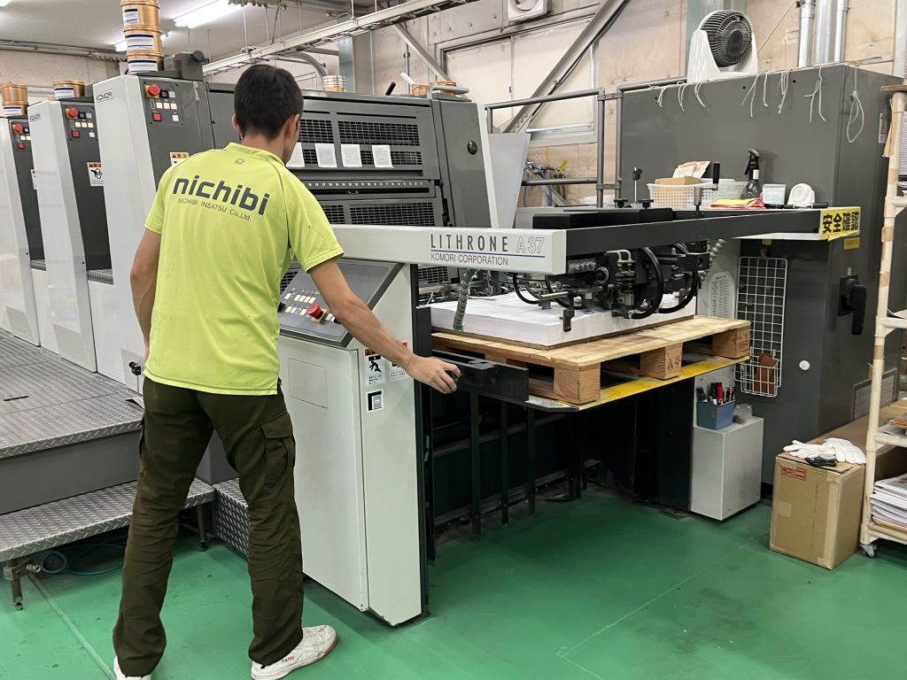 かたぬき印刷アトリエ・日美印刷のオフセット機を操作する印刷オペレーター